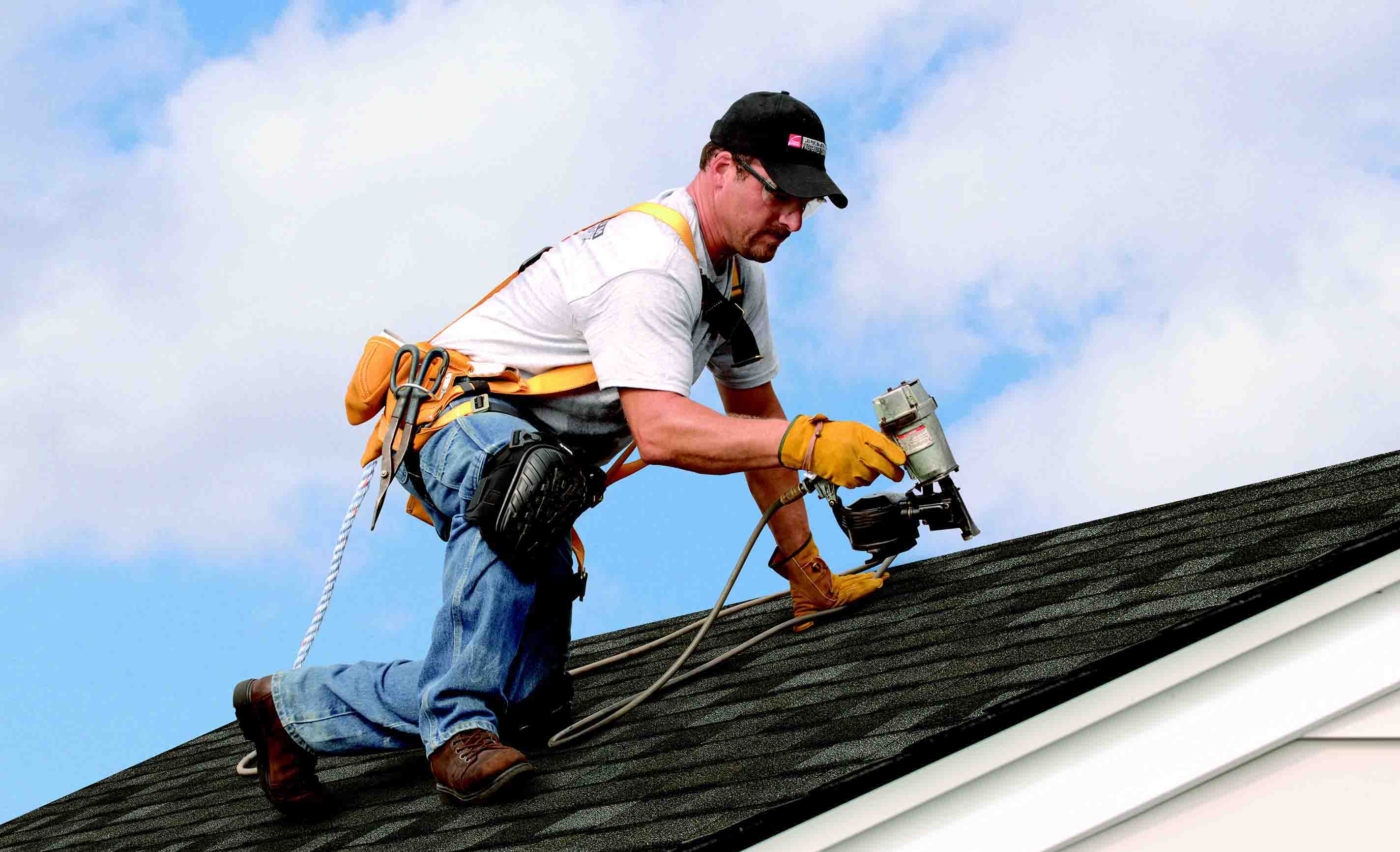 Man on roof with nail gun
